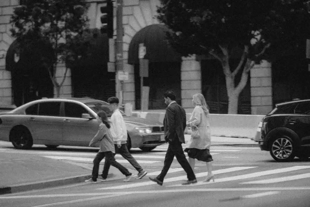 Executive and family crossing the street in a nice area of a city